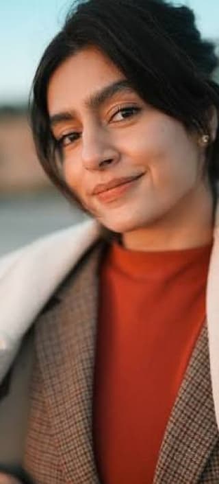 Angely in a rust turtleneck and plaid blazer
